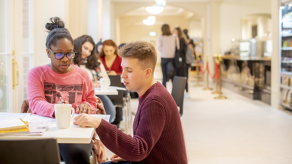 Students sitting and working in the RCM cafe
